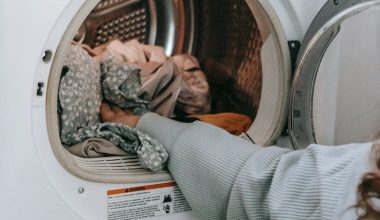 anonymous woman loading clothes in washing machine