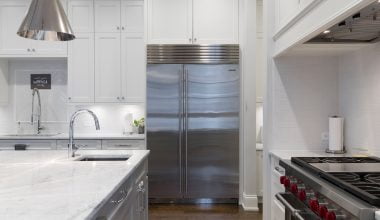 stainless steel refrigerator beside white kitchen cabinet