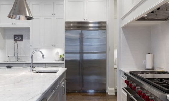 stainless steel refrigerator beside white kitchen cabinet